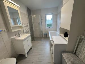 a bathroom with a sink and a toilet and a tub at Ferienwohnung SEESTERN **** in Rostock