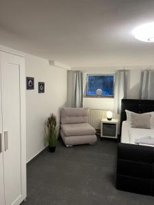 a living room with a couch and a bed and a chair at Souterrain Monteurwohnung mit Sauna und Garten in Rostock