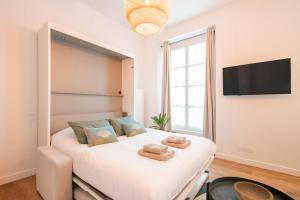 a bedroom with a large white bed with towels on it at Le Laurencin Sens - Le Zen - Cœur de ville in Sens