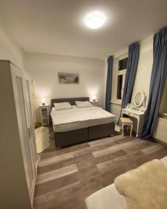 a bedroom with a bed and a desk with a mirror at N A U T I C A - ruhige maritime Ferienwohnung mit Balkon familienfreundlich in Rostock