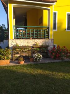 una casa con una panchina e fiori in un cortile di La Villetta a Olmedo