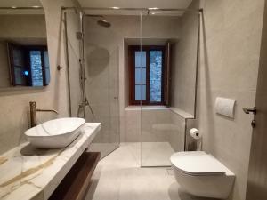 a bathroom with a toilet and a sink and a shower at Μikri Arktos Boutique Hotel in Dhimitsana