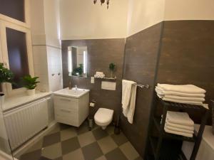 ein Badezimmer mit einem Waschbecken, einem WC und einem Spiegel in der Unterkunft N A U T I C A - ruhige maritime Ferienwohnung mit Balkon familienfreundlich in Rostock
