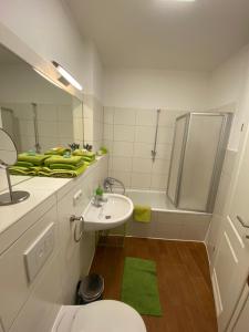a bathroom with a sink and a shower and a toilet at Traumwohnung STÖRTEBEKER ruhig & großzügig zentral in Rostock