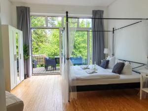 a bedroom with a bed and a sliding glass door at DEUTSCHE VILLA - DELUXE APARTMENT mit Sauna und großem Garten in Rostock