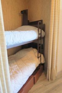 2 Etagenbetten in einem Zimmer mit Vorhängen in der Unterkunft Confortable T2 + Cabine face à la mer 4BALM39 in Le Barcarès