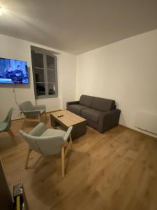 Royat : Superbe appartement en face des Thermes في رويات: غرفة معيشة مع أريكة وطاولة