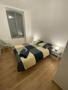 Royat : Superbe appartement en face des Thermes في رويات: غرفة نوم بسرير كبير وملاءات بيضاء وسوداء