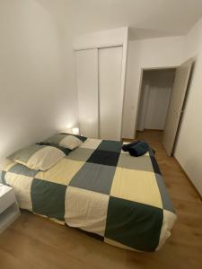Royat : Superbe appartement en face des Thermes في رويات: غرفة نوم بسرير وبطانية بيضاء وسوداء