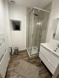 Royat : Superbe appartement en face des Thermes في رويات: حمام مع دش ومغسلة