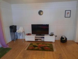 a living room with a flat screen tv on a white wall at Hemtrevlig villa i Billingsfors in Billingsfors