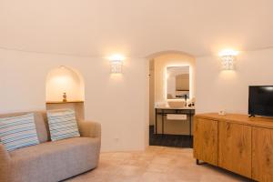 a living room with a couch and a television at Porto Giardino - CDSHotels in Monopoli