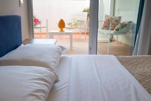 1 dormitorio con cama y vistas a un patio en ZIBIBBO SUITES & ROOMS - Aparthotel in Centro Storico a Trapani en Trapani