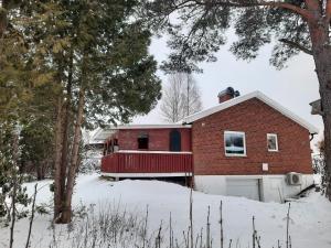 una casa de ladrillo rojo con garaje en la nieve en Hemtrevlig villa, en Billingsfors
