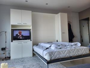 a bedroom with a bed and a flat screen tv at 'Aurore' - Romantic Studio with Seaview in Ostend