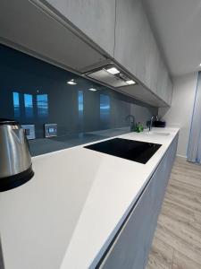 a kitchen with a white counter with a sink at cozy 2 Bed Flat free parking, Manchester City Centre in Manchester