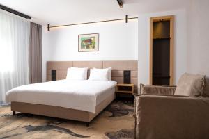 Habitación de hotel con cama y sofá en Alexandrion Experience en Sinaia