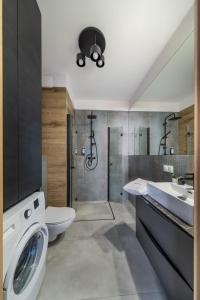 y baño con aseo, lavabo y lavadora. en ResiNest Apartamenty Kameralna Wesoła, en Białystok