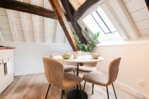 a table and chairs in a room with a window at Le Laurencin Sens - Le Comble - Cœur de ville in Sens