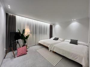 a bedroom with two beds and a television in it at Oasis in Seoul