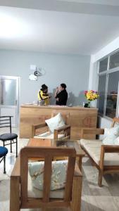 duas pessoas atrás de um balcão numa sala em Hotel Dewa Elegance Tawang em Tawang
