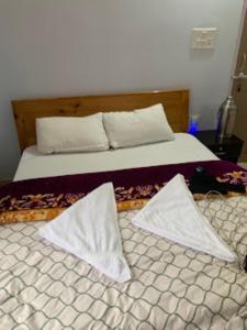 ein Schlafzimmer mit einem Bett mit weißen Kissen in der Unterkunft Hotel Dewa Elegance Tawang in Tawang