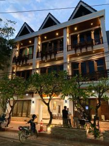 un bâtiment avec des personnes debout devant lui dans l'établissement Vongkhamsene Boutique Hotel, à Ban Nongdouang