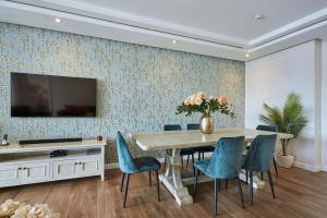 a dining room with a table and blue chairs at Parama 102 in Cape Town