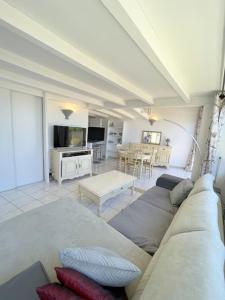 a living room with a couch and a table at Agréable maison avec terrasse et piscine collective -6PQ32 in Le Barcarès