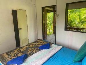 a bed with blue pillows in a room with a mirror at King Kong Restaurant and Bungalows in Muang Không
