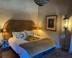 a bedroom with a large bed with a wooden headboard at Le Clos de Mara in Issus