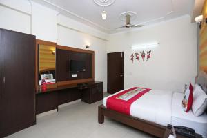 a hotel room with a bed and a television at OYO Hotel Green View in Indirapuram