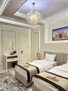 1 dormitorio con 2 camas y lámpara de araña en HAYAT PLAZA HOTEL & Spa, en Samarkand