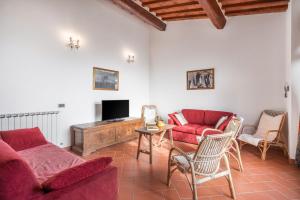 a living room with red couches and a tv at Le Masse in Greve in Chianti