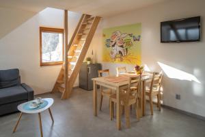 a living room with a dining room table and a staircase at Apartmány pro rodiny s dětmi - Permoník in Dolní Malá Úpa