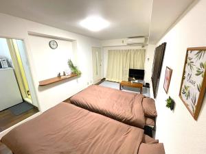 福岡的住宿－SAKURAHOTEL Fukuoka Hatata self check in，小房间设有两张床和一张书桌