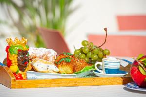 una bandeja de pan y fruta en una mesa en ZIBIBBO SUITES & ROOMS - Aparthotel in Centro Storico a Trapani en Trapani