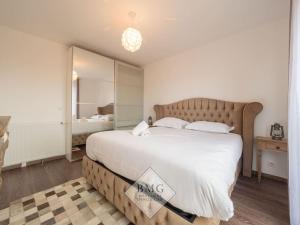 a bedroom with a large bed and a mirror at Disneyland Paris appartement Bmyguest in Chessy