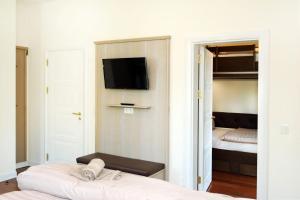 a bedroom with a bed and a tv on a wall at Villa Schmidt - Strandhaus direkt am Meer mit Sauna, Sport und Dünengarten I in Warnemünde