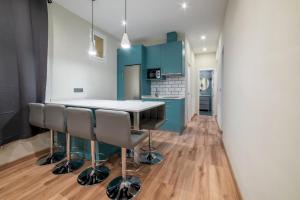 eine Küche mit blauen Schränken sowie einem Tisch und Stühlen in der Unterkunft 2 bedrooms 1.5 bathrooms furnished - Justicia - Refurbished - MintyStay in Madrid
