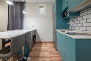 a kitchen with blue cabinets and a sink at 2 bedrooms 1.5 bathrooms furnished - Justicia - Refurbished - MintyStay in Madrid