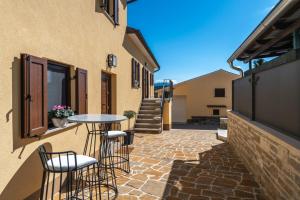 eine Terrasse mit einem Tisch und Stühlen an der Seite eines Gebäudes in der Unterkunft Casa Olika in Buzet