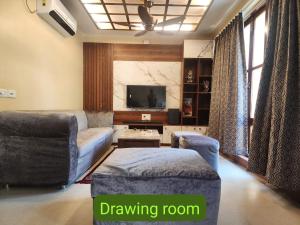 a living room with a couch and a tv at Richak Ganges villa in Kolkata