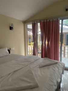 1 dormitorio con cama y ventana grande en Taste of Nature en Canacona