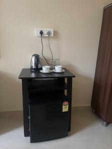 a black table with two cups and glasses on it at Taste of Nature in Canacona