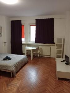 a bedroom with a bed and a desk and window at Romana City Center Studio in Bucharest