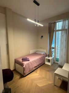 a bedroom with a bed and a large window at Sofo house in Sofia