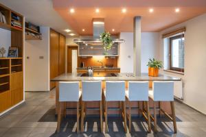 a kitchen with a large island with white chairs at Apartmány pro rodiny s dětmi - Permoník in Dolní Malá Úpa