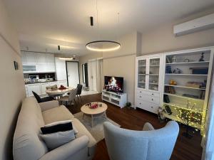 a living room with a couch and chairs and a tv at Sofo house in Sofia