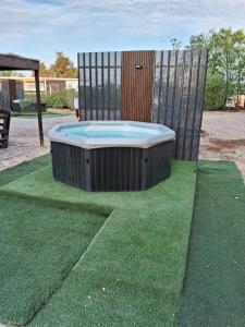 een hot tub op het groene gras bij Cabañas Ecodesert in La Tirana